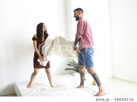Young tattooed stylish couple hugging in bedroom Young tattooed stylish couple hugging in bedroom 56609216