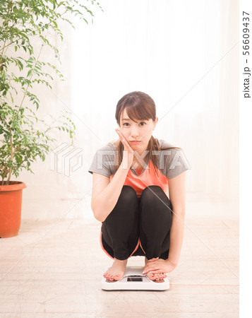 体重を量って落ち込む女性 体重を量って落ち込む女性 56609437