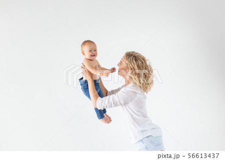 Family, motherhood and family concept - Young mother holding her baby on white background Family, motherhood and family concept - Young mother holding her baby on white background 56613437