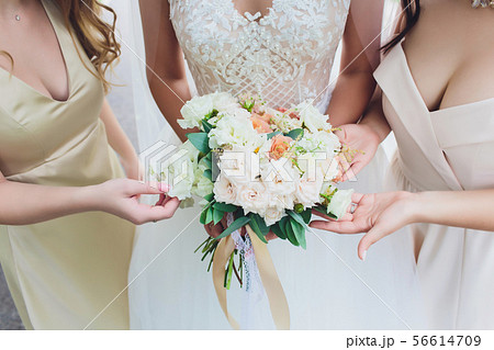 Wedding elegant bouquet in bride's hands. Vivid green bakground. Wedding elegant bouquet in bride's hands. Vivid green bakground. 56614709