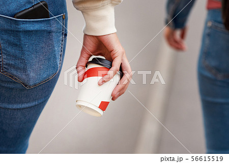 Woman hand with paper cup of coffee take away Woman hand with paper cup of coffee take away 56615519