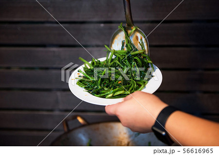 chef scoop hot swamp cabbage to dish 56616965