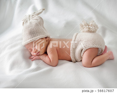 Newborn baby sleeping and wearing rabbit crocheted 56617607