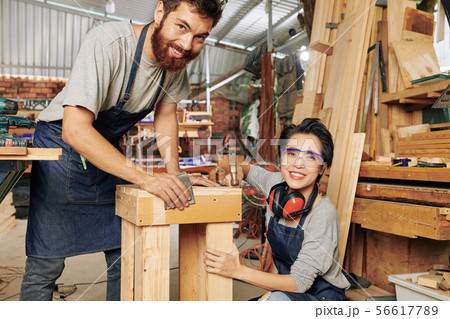 Cheerful carpenters making furniture Cheerful carpenters making furniture 56617789