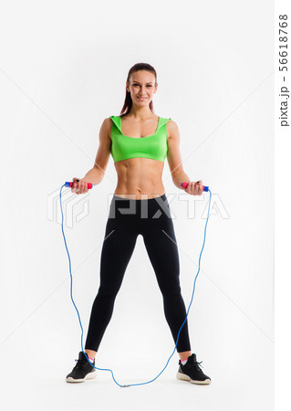Portrait of muscular young woman exercising with jumping rope on white background. Portrait of muscular young woman exercising with jumping rope on white background. 56618768