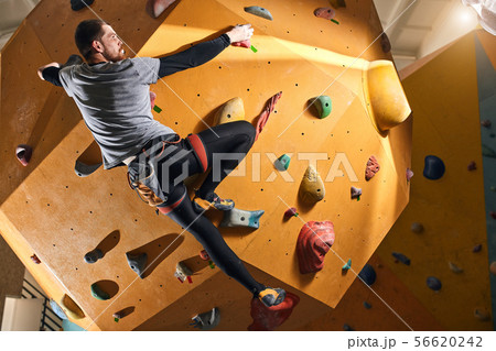 Climber without forearm training at the hardest artificial wall in bouldering gym Climber without forearm training at the hardest artificial wall in bouldering gym 56620242
