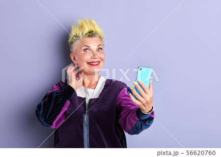 happy sporty senior woman taking selfie with mobile phone indoors 56620760