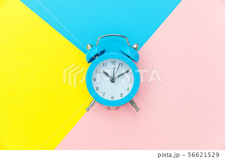 Vintage alarm clock isolated on blue yellow pink pastel colorful trendy geometric background Vintage alarm clock isolated on blue yellow pink pastel colorful trendy geometric background 56621529