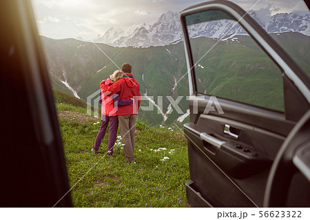 Happy couple hugs on beautiful nature and mountains out of car  56623322