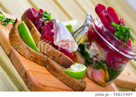 Marinated poutassou served at bread with beets, onions and marinade from lime juice 56625997