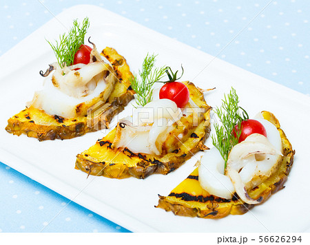 Sepia fried on a grill with pineapple and cherry tomatoes is tasty dish 56626294