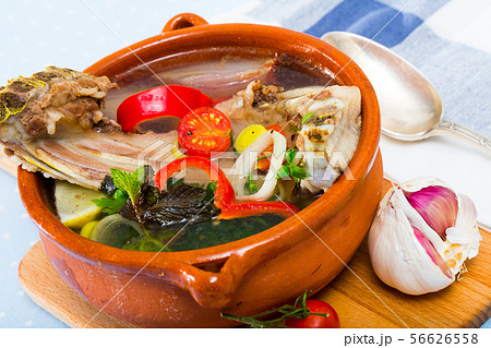 Lamb's soup cooked with vegetables, greens, onion and lemon, served in bowl 56626558