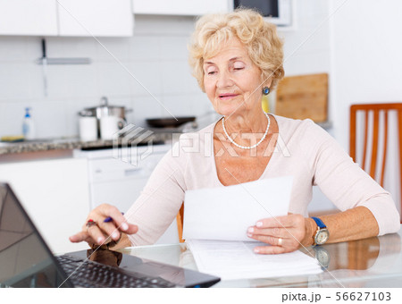 Senior woman filling up documents Senior woman filling up documents 56627103