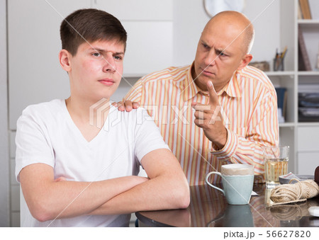 Unhappy man lecturing his son Unhappy man lecturing his son 56627820