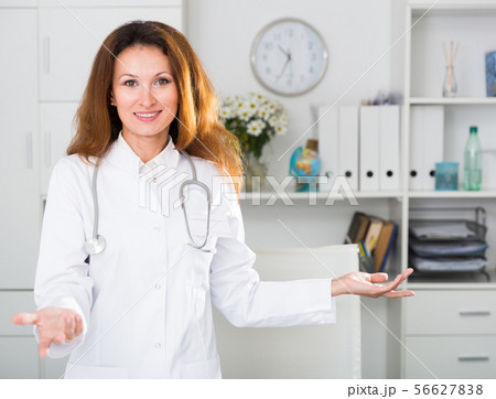 Portrait of female doctor who is working and posing on her workplace Portrait of female doctor who is working and posing on her workplace 56627838