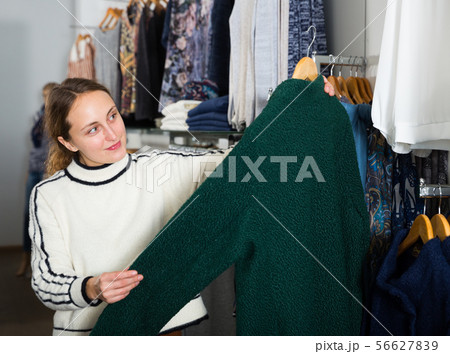 Woman shopping in outerwear clothing boutique 56627839