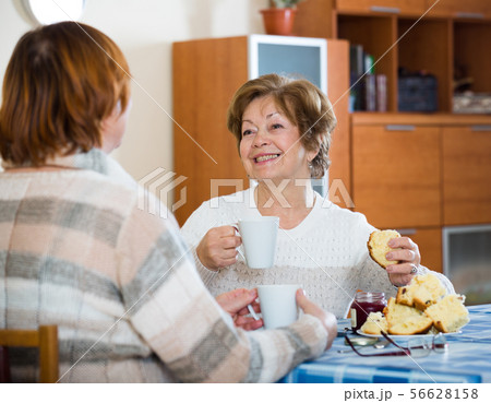 Happy mature women drinking tea and chatting 56628158