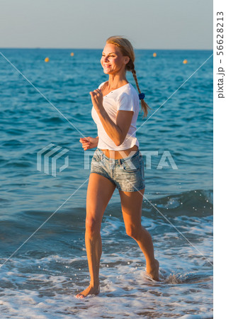 Female in white T-shirt is jogging 56628213