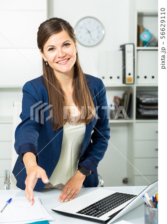 Successful businesswoman standing in office with open hand ready for handshake 56629110