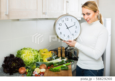 Housewife with clocks at kitchen Housewife with clocks at kitchen 56629260