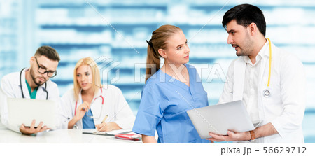 Doctor working in hospital with other doctors. 56629712