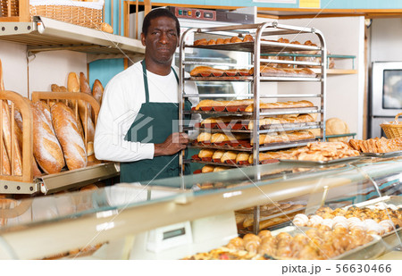 Baker working behind counter in bakeshop Baker working behind counter in bakeshop 56630466