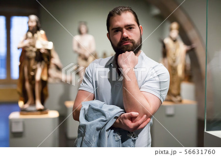 Man looking at stone architectural elements in historical museum hall Man looking at stone architectural elements in historical museum hall 56631760