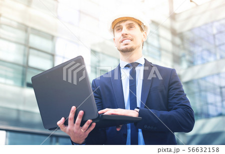 Portrait of positive man builder work at the laptop 56632158