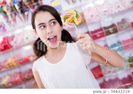 emotional schoolgirl standing with lollipop 56632219
