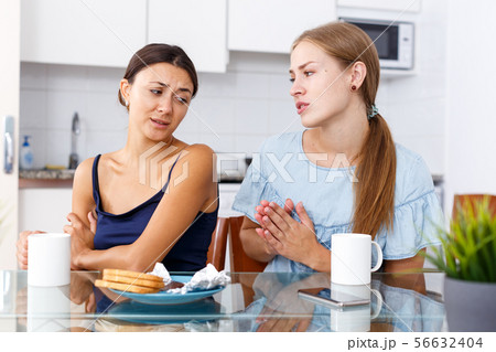 Woman apologizing from offended friend Woman apologizing from offended friend 56632404