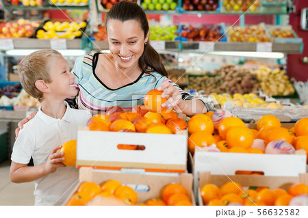 Portrait of happy woman and her little son choosing oranges at shop 56632582
