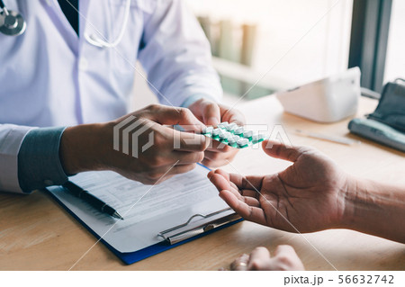 Doctor is pointing to drug tablet and introducing 56632742