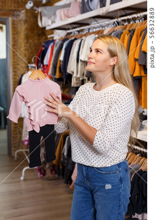 Woman choosing baby clothes Woman choosing baby clothes 56632889
