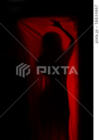 Woman behind red curtains Woman behind red curtains 56634667