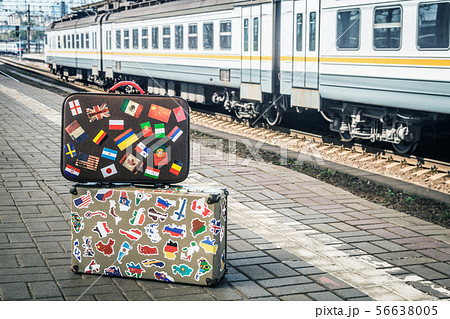 suitcases with stickers from around the world stands on the platform 56638005