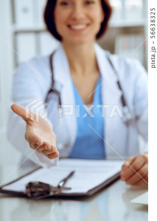 Closeup of medicine doctor offering helping hand or handshake. Partnership and trust concept 56638325