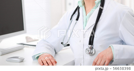 Doctor woman sitting at the desk with computer at workplace in hospital office. Unknown physician's 56638398