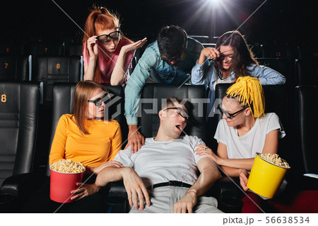 sleeping young man in 3d glasses disturbing his friends during the session 56638534