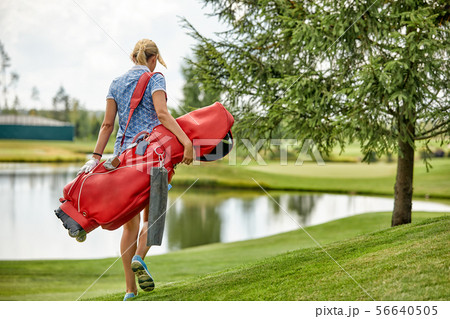 Golf concept, copy space. Women golf time holding golf equipment on green field background. The 56640505