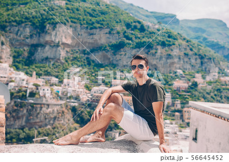Summer holiday in Italy. Young man in Positano village on the background, Amalfi Coast, Italy Summer holiday in Italy. Young man in Positano village on the background, Amalfi Coast, Italy 56645452