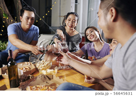 Friends toasting with wine glasses 56645631