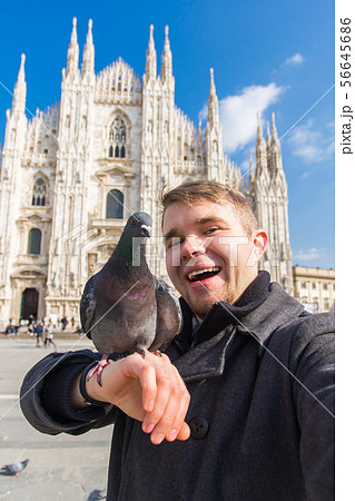 Travel, holidays and winter vacations concept - Happy man take selfie photo with funny pigeons in 56645686