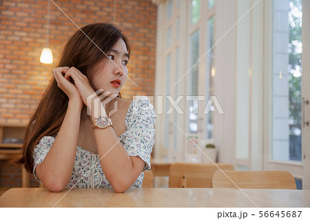 Asian woman relaxing to wait hot coffee latte art 56645687
