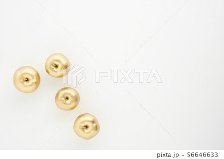 A group of seven gold painted metallic paint apples on a white background. 56646633