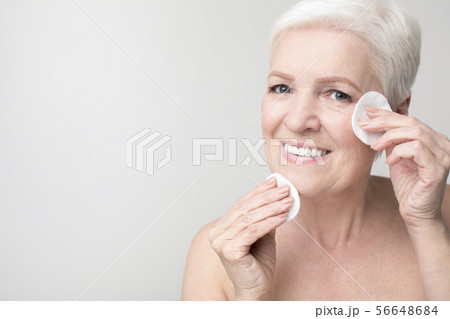 Mature woman using cotton pad for removing make up 56648684