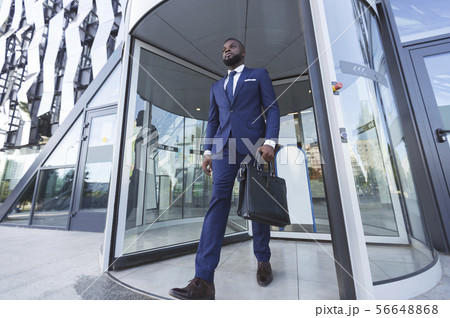 Confident Afro Businessman With Briefcase Leaving Modern Office Building 56648868