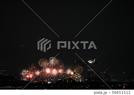 夜空に舞う花火と飛行機の写真素材