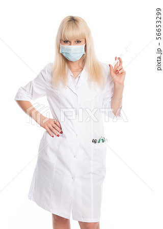 Masked nurse with syringe in hand. Masked nurse with syringe in hand. 56653299