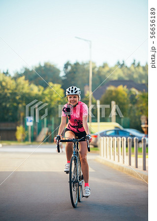 Picture of young woman in helmet on bike ride on summer day Picture of young woman in helmet on bike ride on summer day 56656189