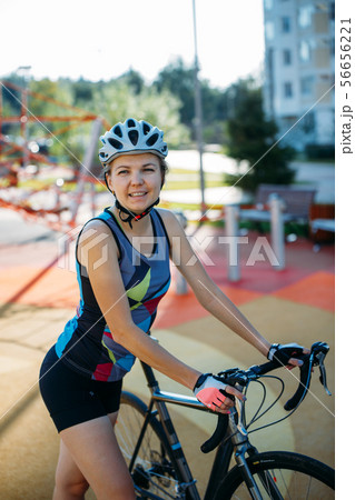 Photo of young woman in helmet on bike ride on summer day 56656221